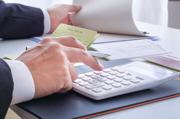 電卓でお金の計算をする人の手元